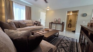 Ein Wohnzimmer mit einer Couch, einem Couchtisch und einem gemusterten Teppich.