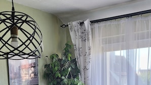 A room with a wooden desk, a black chair, a round table, a globe, and a plant. - Studio proche du centre de Colmar avec jardin privatif (Colmar)