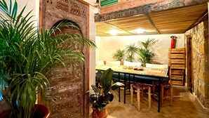 A dining area with a rustic wooden table and chairs, surrounded by potted plants. - Taghazout ocean view (Taghazout)