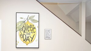 A dining area with a black table, a framed inspirational quote, and a small potted plant.