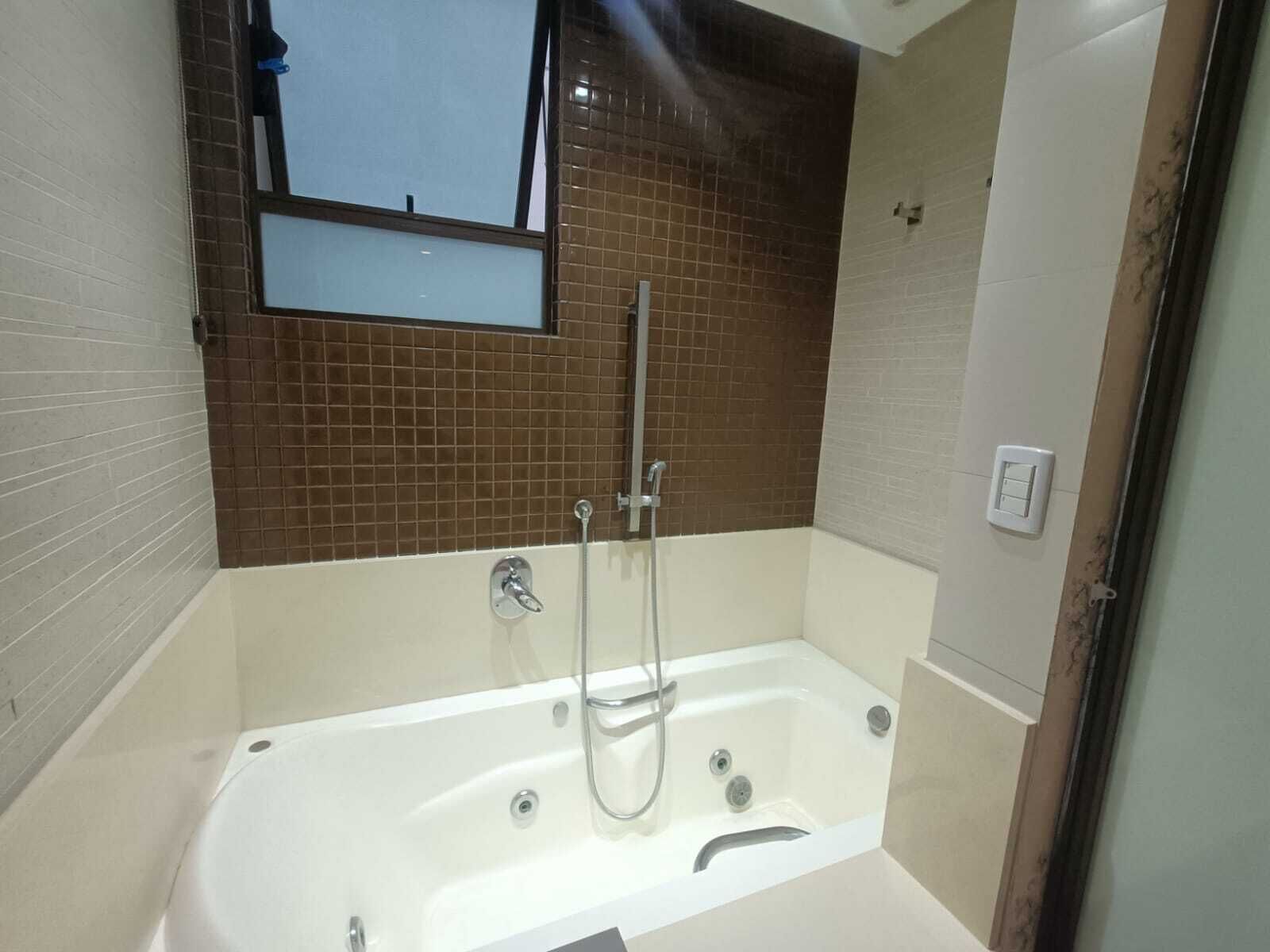Une salle de bain avec une baignoire, une douche et une fenêtre.