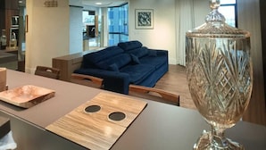 En moderne stue med en blå sofa, et træbord og en dekorativ glasvase.