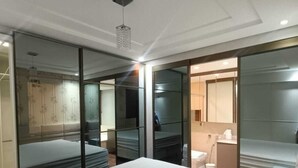 Et moderne hotelværelse med en stor seng, en glasafskærmning og et separat badeværelsesområde.