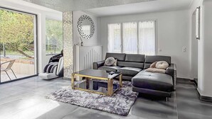 A modern living room with a sectional sofa, a glass coffee table, and a large mirror on the wall.