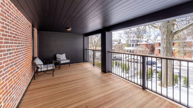 A covered balcony with a wooden floor, a metal railing, and a view of the street. - The Francis Hotel & Suites (Kennett Square)
