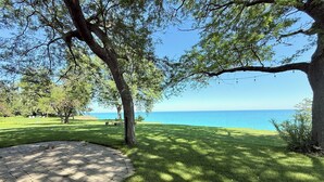 Un sendero pavimentado que conduce a una zona verde con vista al mar.