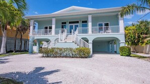 A two-story building with a light blue exterior, a covered front porch, and a staircase leading to the upper level.