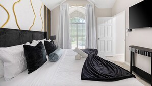 A bedroom with a bed, a TV, and a door. - The Pony Haus – Pool, Spa +Climbing Wall sleeps 11 in Frisco TX! (Frisco)