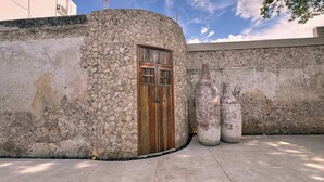 Um muro de pedra com uma porta de madeira e duas grandes esculturas de concreto.