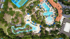An aerial view of a resort with multiple swimming pools, a winding water slide, and a variety of outdoor seating areas. - Stunning 7 br Solterra's pool JEWEL! The Resort is your Backyard! (Davenport)