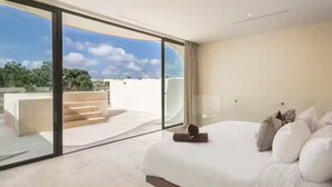 A modern bedroom with a large bed, a view of the outdoors, and a balcony. - Luxury Boho Villa w/ Pool, 5 Min to Tulum Beach (Tulum)
