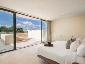 A modern bedroom with a large bed, a view of the outdoors, and a balcony.