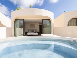 A modern hotel with a swimming pool, a bedroom with a bed and curtains, and a balcony with greenery.