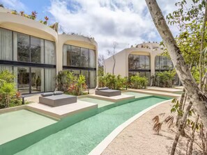 A modern pool area with lounge seating and a clear view of the sky.