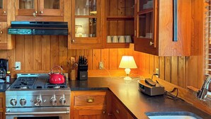 A kitchen with wooden cabinets, a stove, and a sink. - Newly Updated Historic Baton Rouge Home, Near LSU & Downtown--3 BR/Sleeps 6 (Baton Rouge)