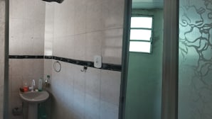 A bathroom with a sink, mirror, and a window. - Village Apartment Building (Rio de Janeiro)