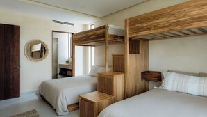 A bedroom with two beds, wooden headboards, a mirror, and a small wooden cabinet.
