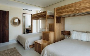 A bedroom with two beds, wooden headboards, a mirror, and a small wooden cabinet. - Oceanfront Escape – Two-Level Penthouse with Private Rooftop & Pool (Tulum)