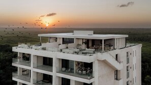 Un edificio moderno a più piani con terrazza sul tetto, ampie finestre e un design dal tetto piatto.