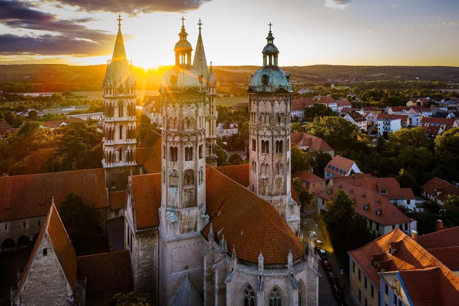 Une église historique dotée de plusieurs tours, dont un clocher imposant, et entourée d’immeubles d’habitation.