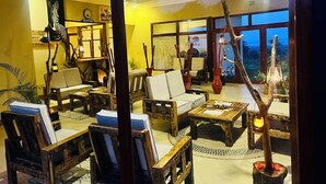 Un'accogliente area con posti a sedere interna, con mobili in legno, una reception e vista attraverso ampie finestre.