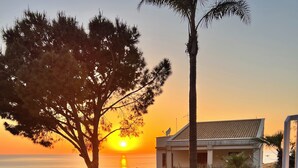 A residential area with a house, a garden, and a sunset view.