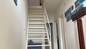 A staircase leading to a landing with a blue couch.