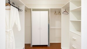 A walk-in closet with a wooden floor, white cabinetry, and a full-length mirror. - Luxury room + Pool + Ensuite (Bradbury)