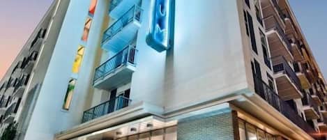 Et moderne hotel med en markant indgang, flere balkoner og et tydeligt skilt med Spectrum.