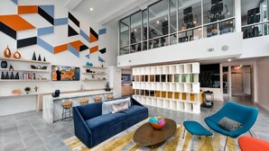 A modern interior with a blue sofa, a coffee table, and a vibrant rug. - BCA Spectacular Apartments (Atlanta)