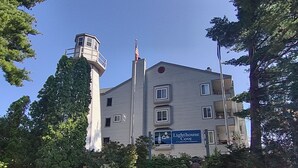 En bygning med flere etager, et fyrtårn, et flagstang med det amerikanske flag og et skilt, der angiver, at det er et ejerlaug.
