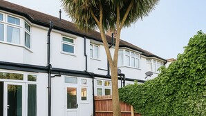 Un immobile residenziale con patio arredato e un albero.