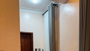 A laundry room with a washing machine, a door, and a curtain. - Clover Homes Ug (Kampala)