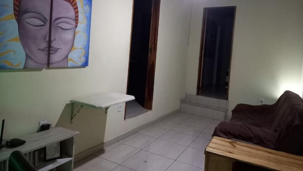 Una habitación con un cuadro, un escritorio, una cama y dos puertas.
