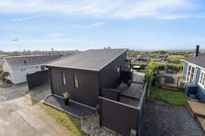 Een moderne woonwijk met huizen, een heldere lucht en een verre zeespiegel.