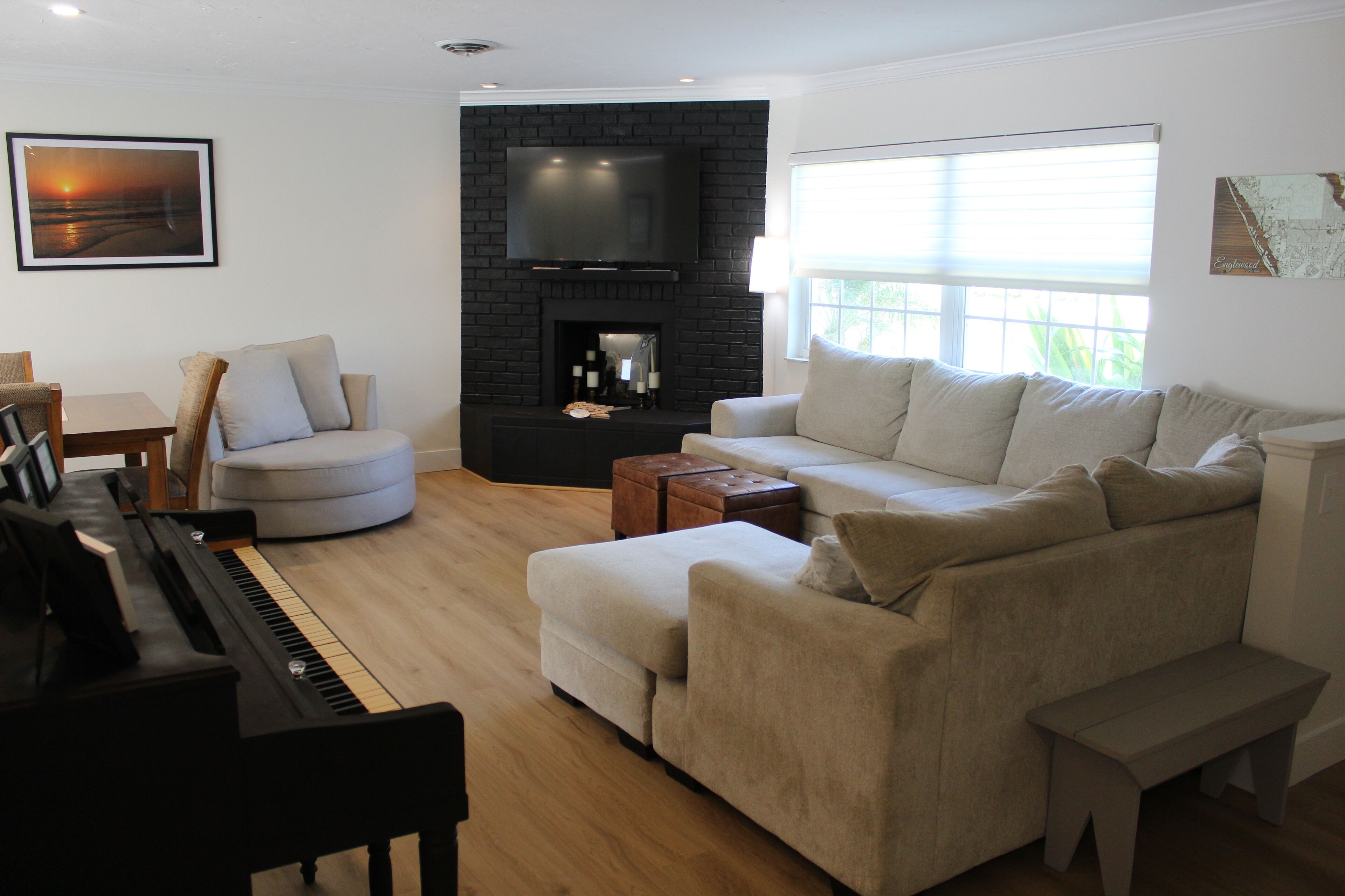 A living room with a piano, a sofa, a coffee table, and a fireplace.