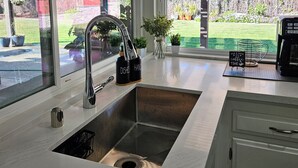 Una cucina moderna con un'ampia finestra, un lavello incassato e un angolo caffè.
