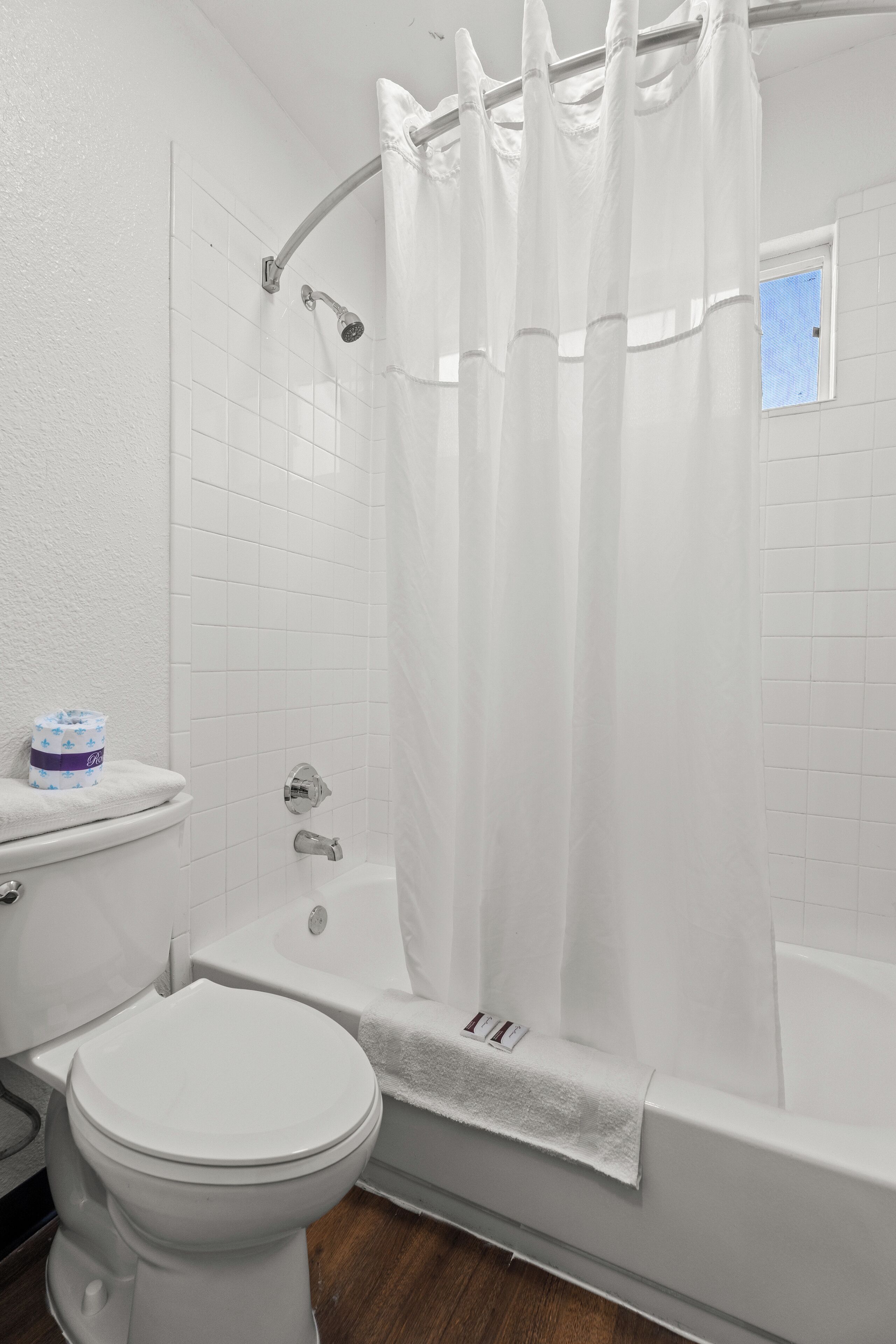 A bathroom with a toilet, bathtub, and shower curtain.