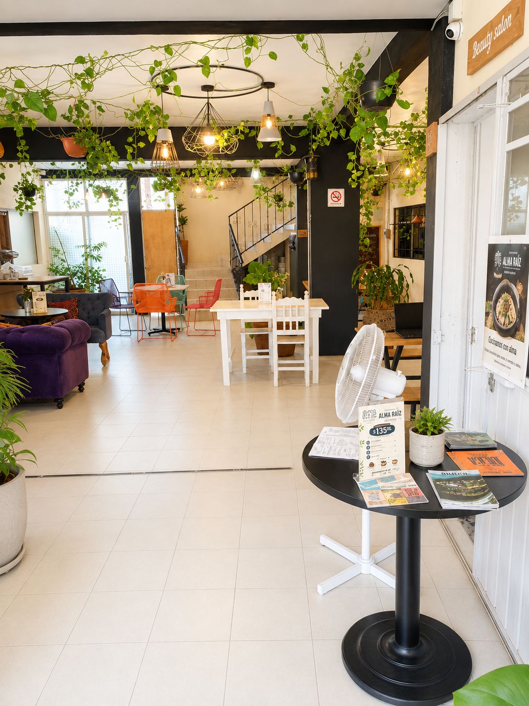 Un intérieur moderne comprenant un espace repas, un comptoir d’accueil et un escalier.