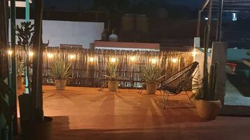 An outdoor patio area with potted plants and a hammock.