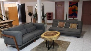 A living room with two grey sofas, a wooden coffee table, and a woven chair. - Casa Biche Jalatlaco Jalatlaco Downtown Oaxaca (Oaxaca de Juárez)