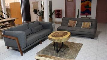 A living room with two grey sofas, a wooden coffee table, and a woven chair.