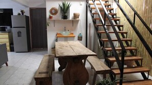 A kitchen with a wooden table and bench, a staircase, and a sink. - Casa Biche Jalatlaco Jalatlaco Downtown Oaxaca (Oaxaca de Juárez)