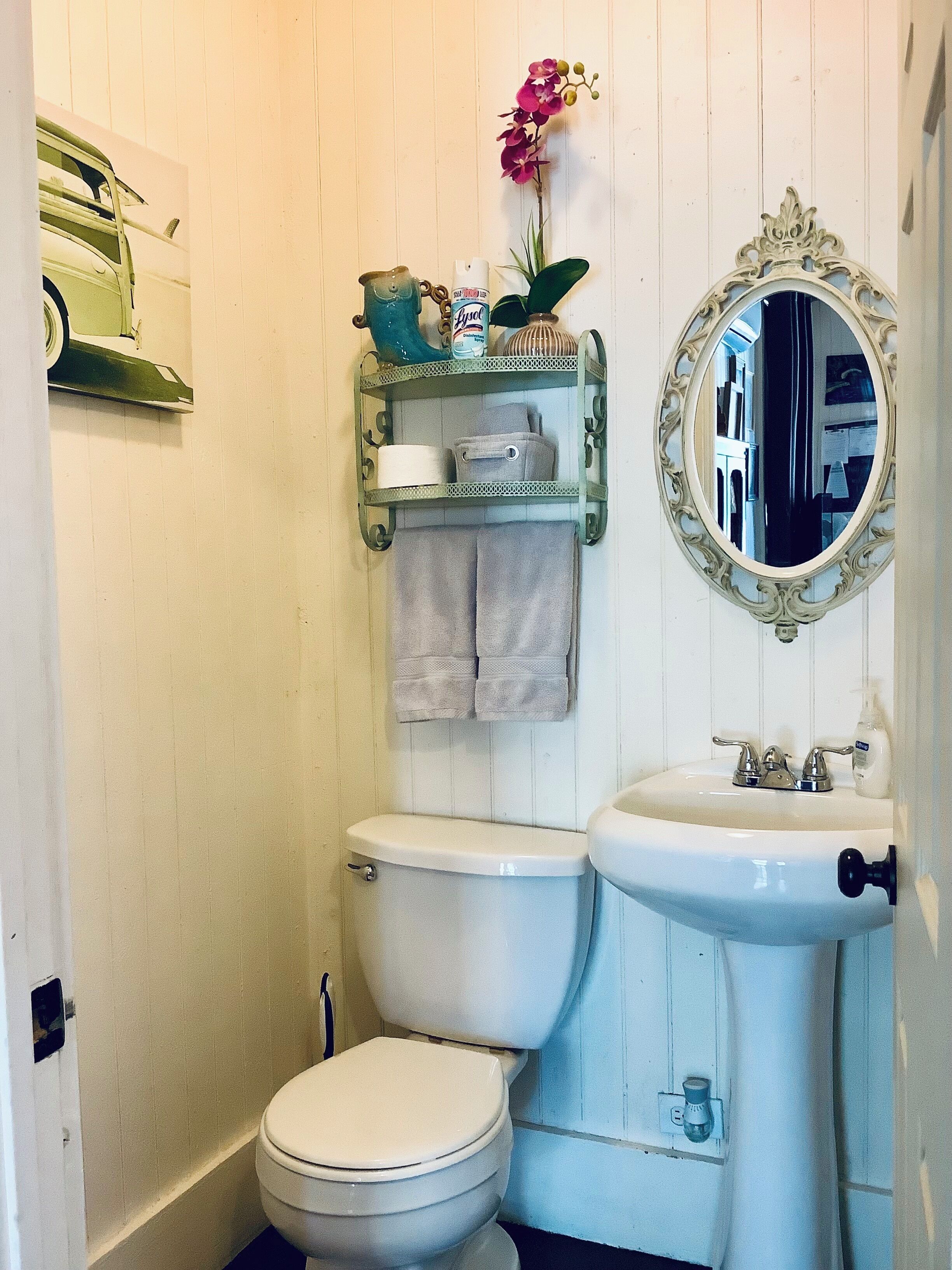 Un bagno con il water, un lavandino e elementi decorativi come uno specchio e degli asciugamani.
