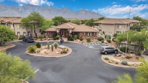 A residential area with houses, a parking lot, and a mountain backdrop.