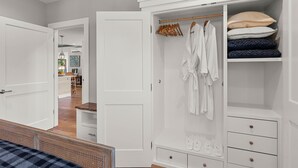 A bedroom with a bed, a white wardrobe, and a closet with hanging clothes and folded items. - Modern Gorge Retreat • Hot Tub • Mountain Views (Cascade Locks)