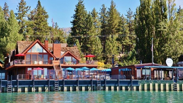 A waterfront property with a main building featuring multiple decks and outdoor seating areas. - Tahoe Vista Inn Suite 7 (Tahoe Vista)