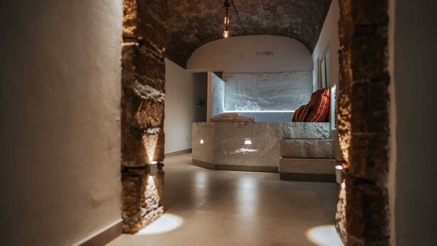 A modern interior with a stone archway leading to a reception area with a sofa and a window. - Suite with private spa in the heart of Palermo✨️ (Palermo)