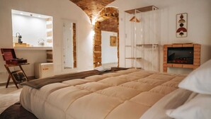 A bedroom with a large bed, a fireplace, a mirror, and a wardrobe. - Suite with private spa in the heart of Palermo✨️ (Palermo)