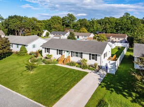 A residential area with single-story houses, well-maintained lawns, and a clear sky.